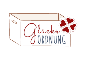 Logo von GlücksOrdnung: eine Kiste mit dem Schriftzug GlücksOrdnung und ein rotes Kleeblatt